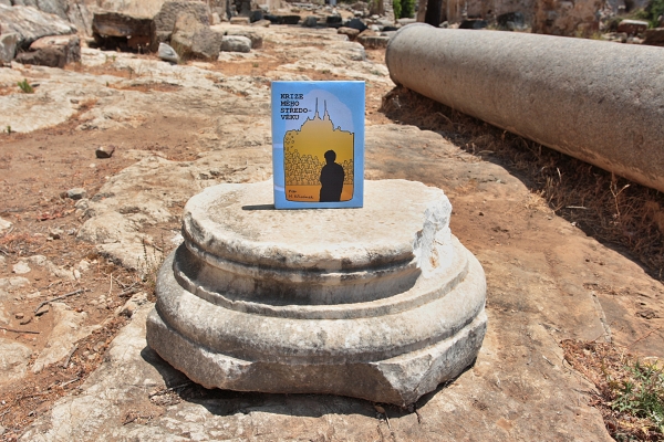 kniha Krize mého středo-věku postavená na sloupu v ruinách římského města