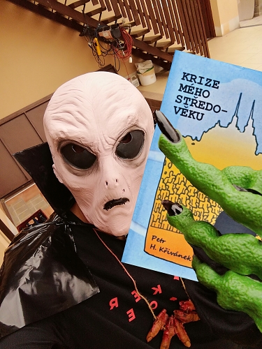odpornej a hnusnej mimozemšťan držící v ruce knihu Krize mého středo-věku od Petr H. Křivánka