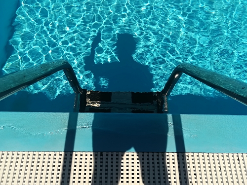 stín plovoucí na hladině vody v bazénu