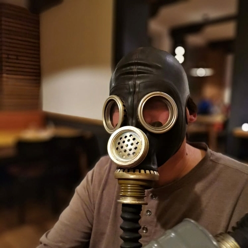muž v plynové masce s dýchacím chobotem