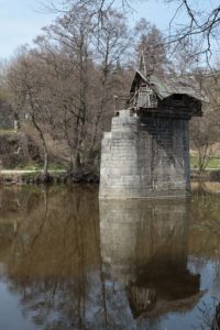 chatrč na pilíři mostu nad řekou